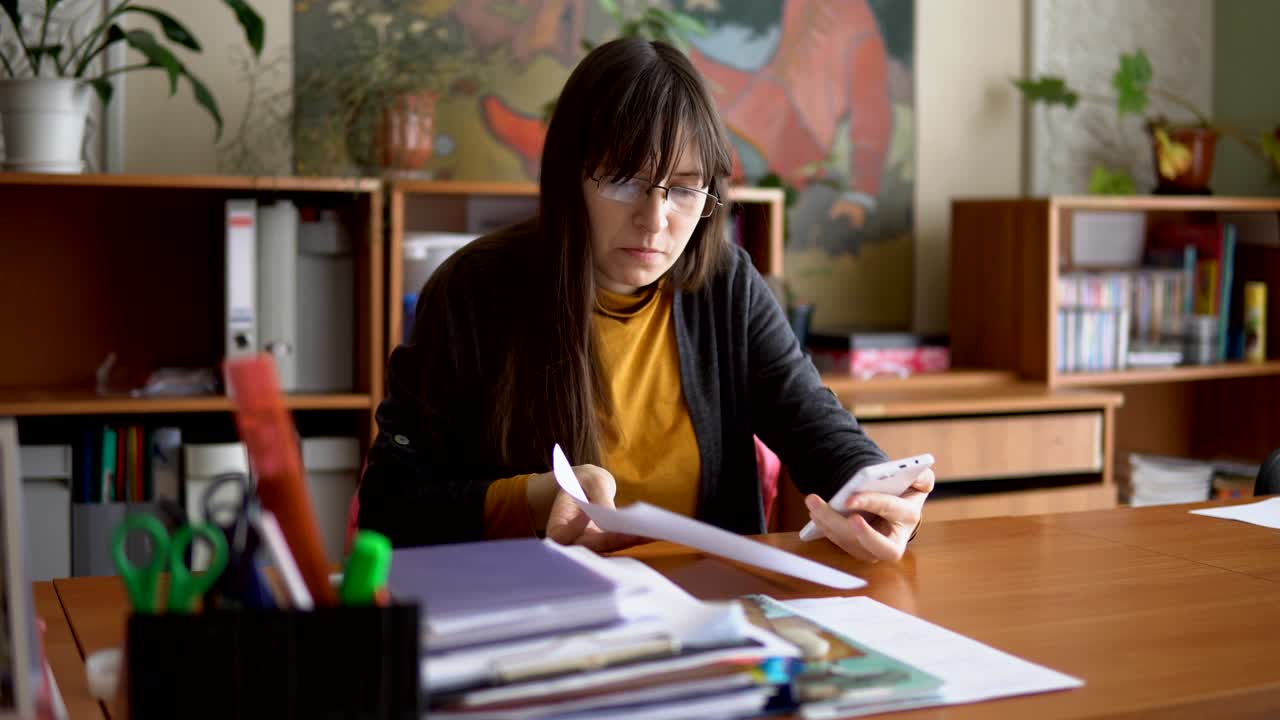 el joven maestro con gafas en el aula comprobando pruebas independientes.