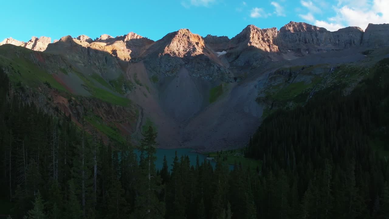 Sunset dusk Lower Blue Lake Mount Sneffels Wilderness Ridgway Telluride Colorado aerial drone golden hour shaded peaks San Juan Rocky Mountains Uncompahgre National Forest blue sky clouds upward