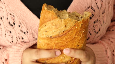 woman holding a piece of whole wheat bread