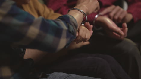 primer plano de una familia sikh masculina de varias generaciones usando y discutiendo brazaletes o pulseras tradicionales de plata sentados en el sofá en casa filmado en tiempo real 1