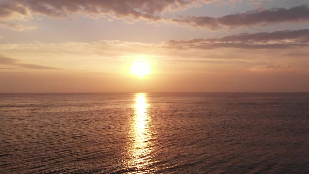 View from a Drone Flying toward the Sunrise over the Sea
