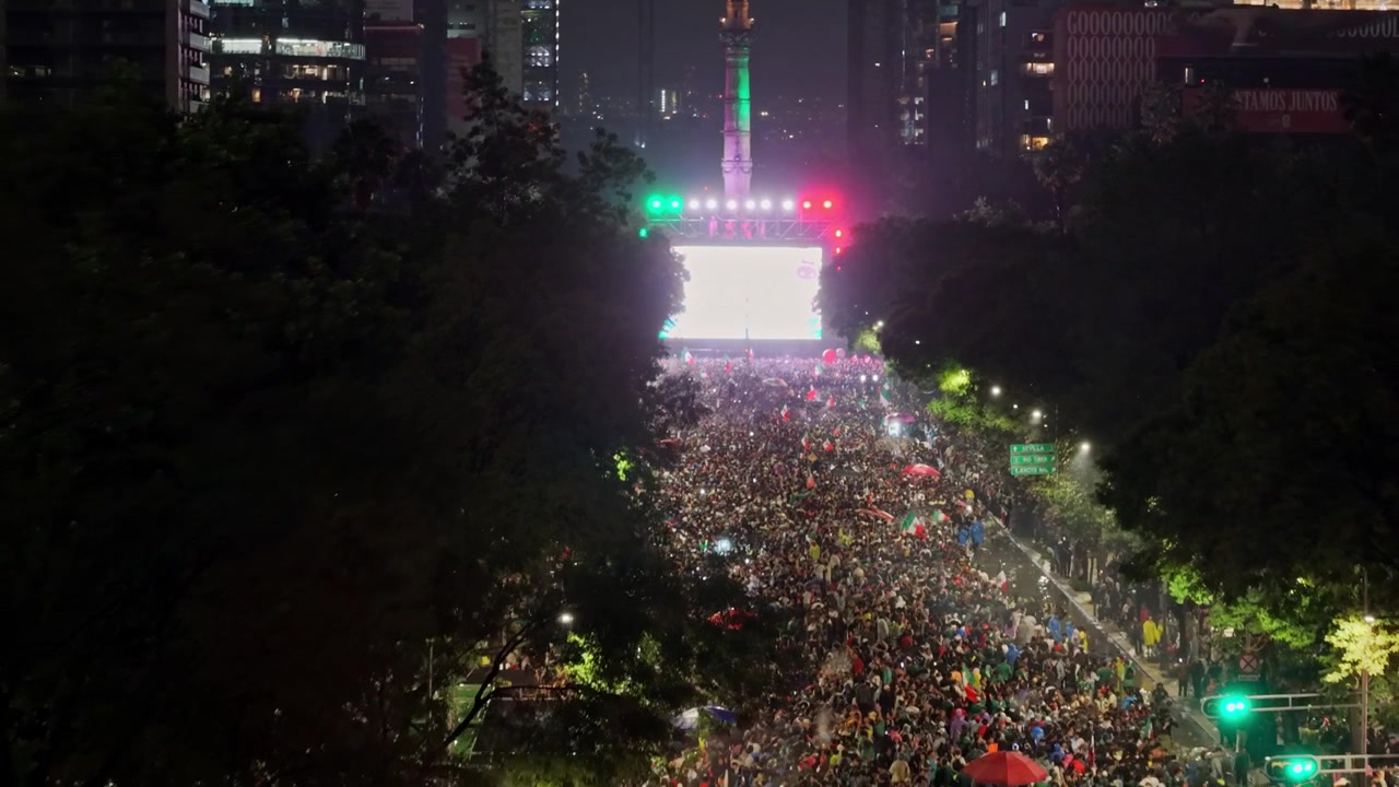 Veduta aerea di una folla che celebra la vittoria del Messico alla Coppa del Mondo, CDMX di notte, Monumento all'Indipendenza, Messico.