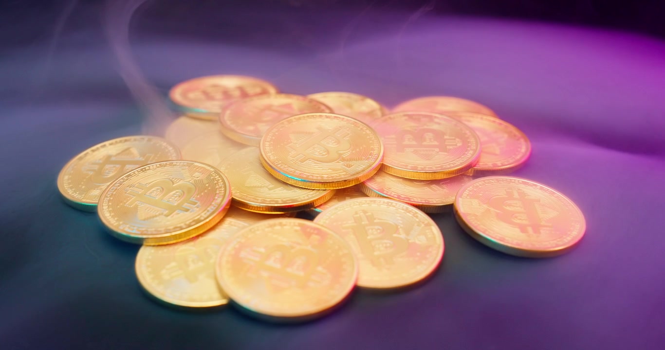 Close-up of Golden Bitcoin Coins with Smoke and Vibrant Lighting