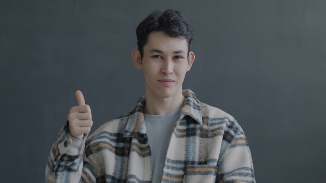Young Man Smiling and Giving a Thumbs Up