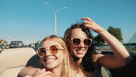 dos mujeres disfrutando de un viaje por carretera en un descapotable