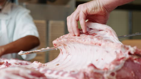 Metzger-Sägt-Fleisch-Zum-Verkauf-In-Einer-Metzgerei,-Nahaufnahme