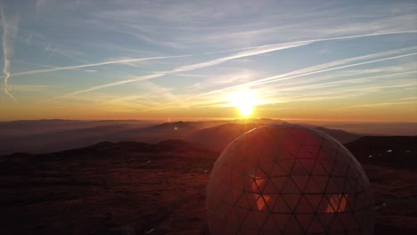 sunset over mountains with radar dome