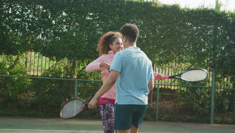 Video-De-Una-Feliz-Pareja-Birracial-Jugando-Tenis-En-La-Cancha