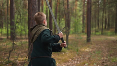 peasant boy runs with sword in his hands through forest