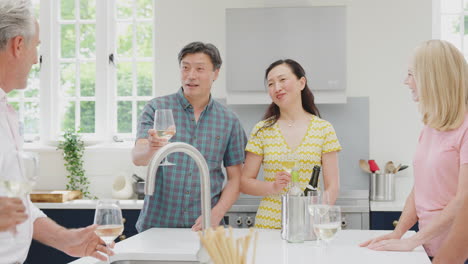 group of multi-cultural senior friends on summer vacation meeting for drinks in holiday apartment