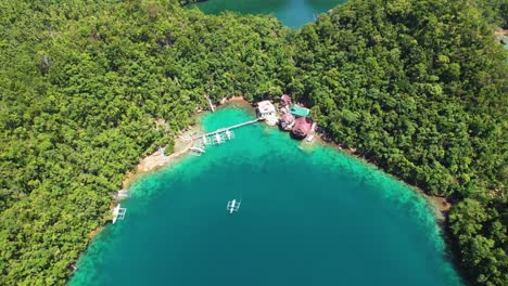 4k drone video flying back and panning up to reveal the stunning nature all around tiktikan lagoon cottages in sohoton cove near siargao island in the philippines