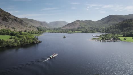 A-steamer-boat-on-Ullswater-lake-in-the-English-Lake-District-sails-towards-Glenridding-on-a-bright-sunny-summer-day