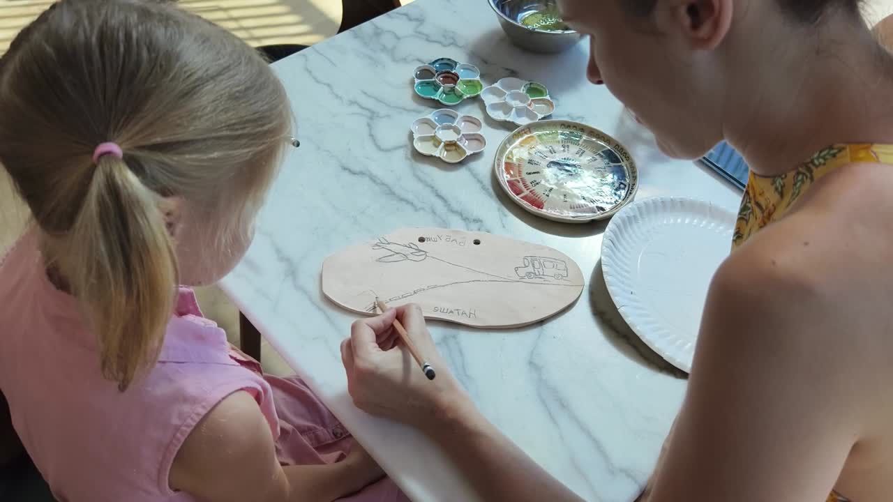 어머니와 딸이 함께 그림을 그리고 있습니다.