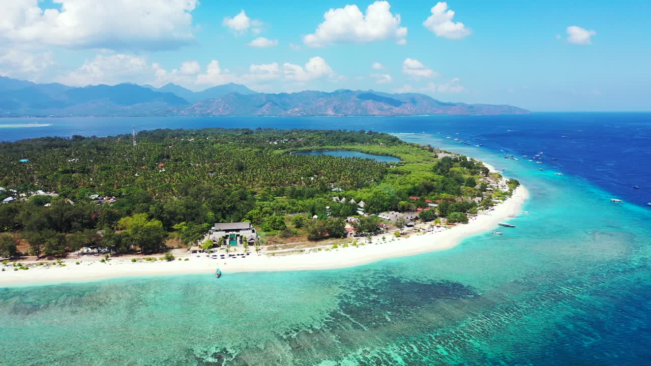 발리의 푸른 청록색 석호로 둘러싸인 휴가 리조트 주변의 무성한 초목과 야자수 숲이 있는 파라다이스 열대 섬 휴가 관문