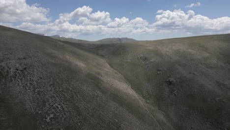 Aerial-climbs-barren-summit-ridge-meadow,-Telluride-Colorado-mountains