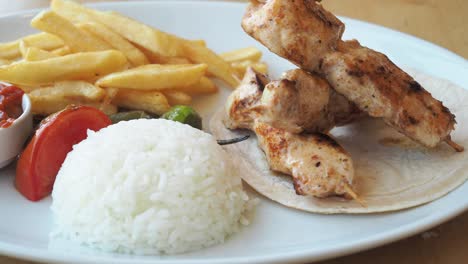 chicken skewers with rice and fries