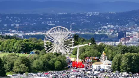 close-up of the ferris wheel at tivoli in ekebergsletta during the norway cup 2023 with downtown oslo in the background