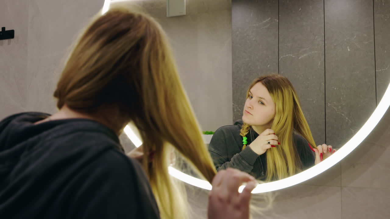 Donna che si acconcia i capelli in bagno
