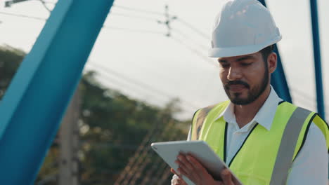 engineer inspecting bridge with tablet