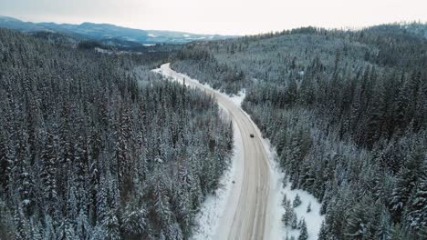 加拿大不列颠哥伦比亚省美丽的雪地荒野中黑色的汽车:在24号小堡高速公路上的平静的冬季场景