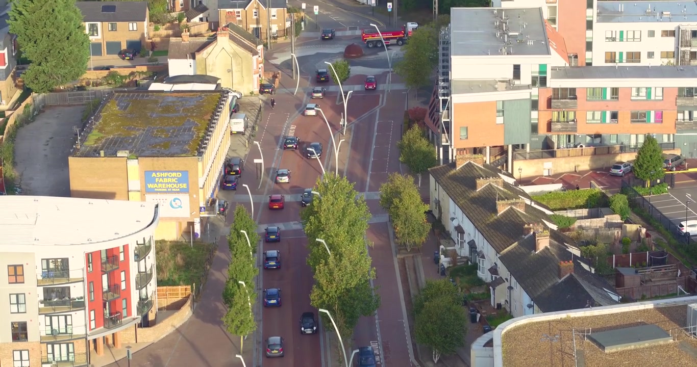 Ripresa aerea dall'alto con panoramica rivelatrice del traffico dell'ora di punta mattutina ad Ashford, Kent.