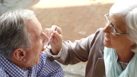 senior woman feeding sweet food to senior man in cafã© 4k