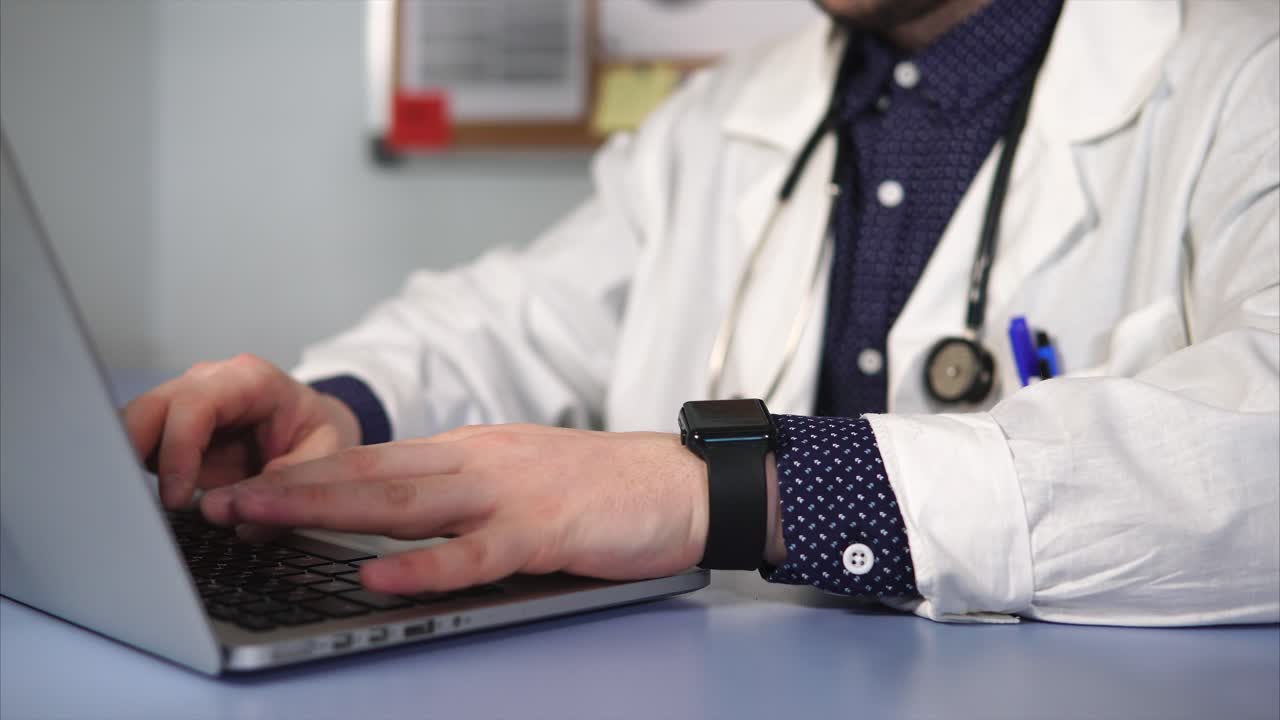 médico trabajando en una computadora portátil