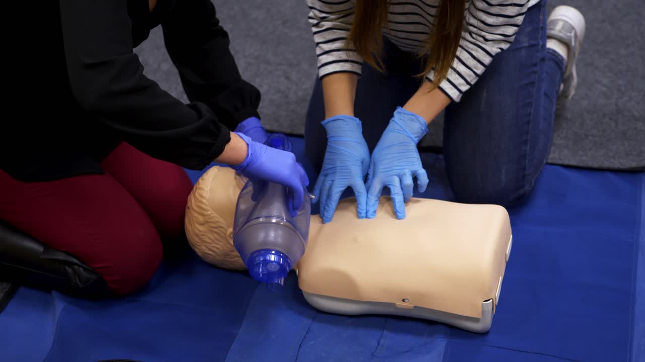 First aid training indoors. People learning how to save life when the baby is choked with instructor