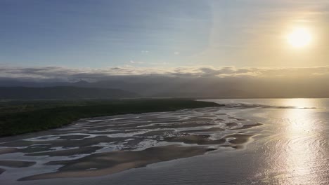 drone captures serene sunrise over daintree river, highlighting reflective waters and lush mangroves in port douglas, australia