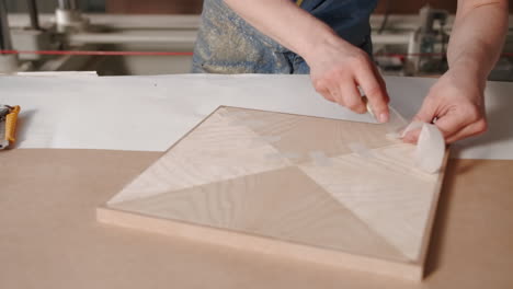 woodworking process: applying adhesive tape to a wood panel