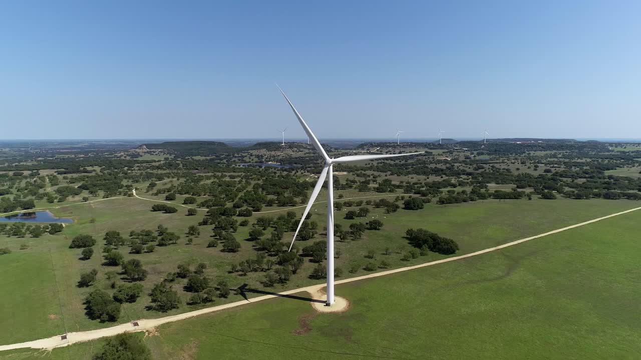 Aerial video of a wind turbine.  Camera backs away from the wind turbine revealing vast open field.  This was shot near Comanche Texas.