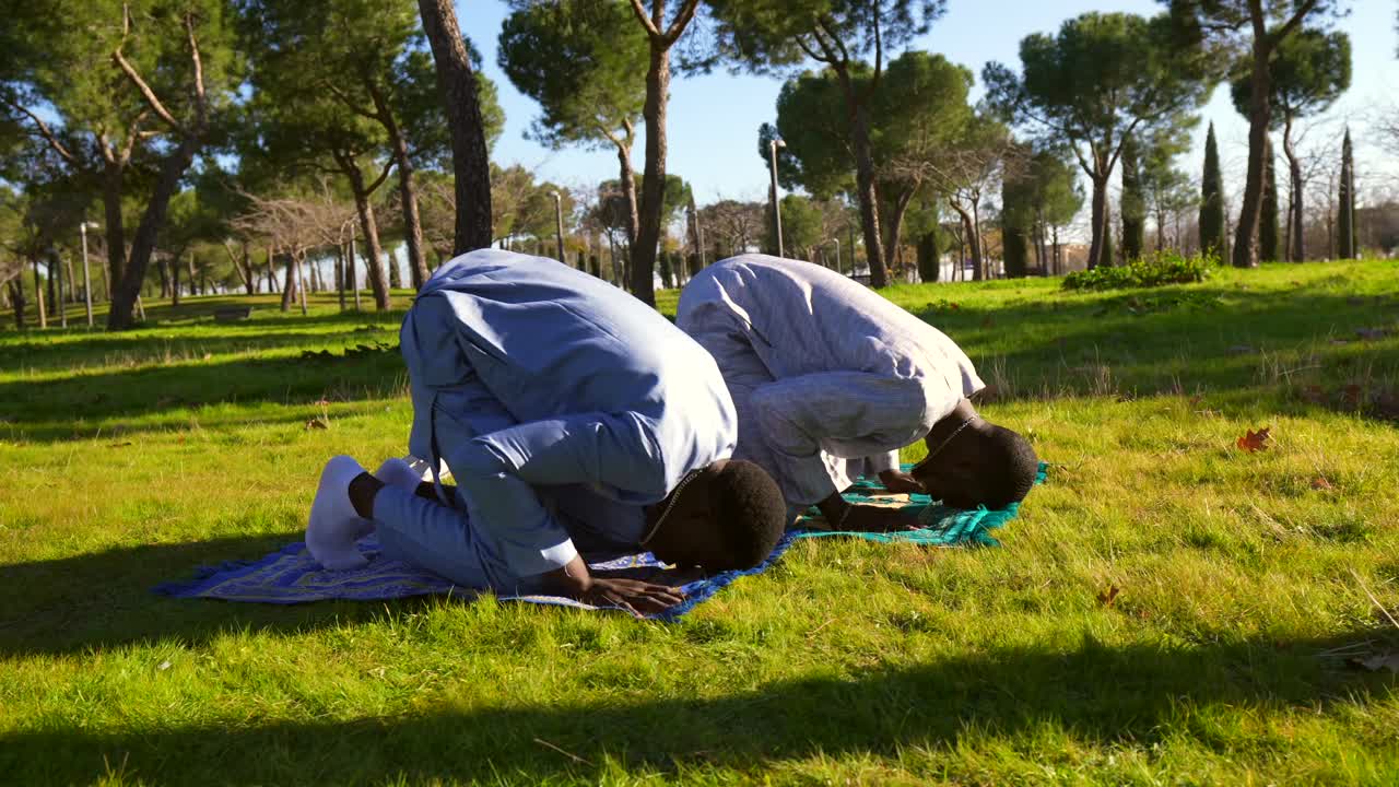 Muslimimiehet rukoilevat ulkona puistossa