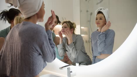 tres mujeres jóvenes riendo y hablando en el baño