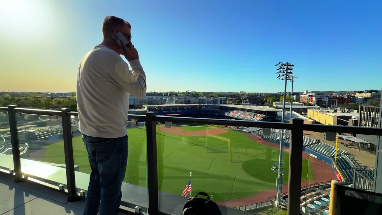 Man Talking On A Phone Call At First Horizon Park, Minor League Baseball Stadium in Nashville, USA