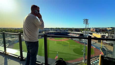 man talking on a phone call at first horizon park, minor league baseball stadium in nashville, usa