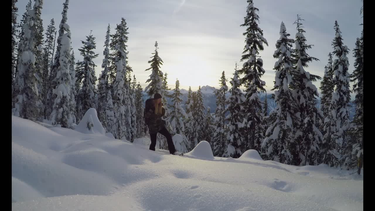 mujer con mochila caminando por la pendiente de la montaña cubierta de nieve 4k