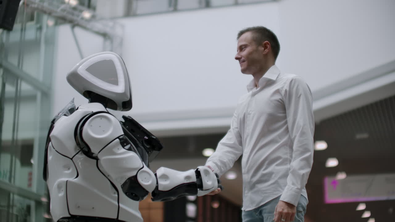 interacción del hombre y las tecnologías modernas de inteligencia artificial. cerca de la mano masculina del científico sacude el brazo robótico. manos robóticas y humanas se unen en un apretón de manos. reunión y saludo de amigos.