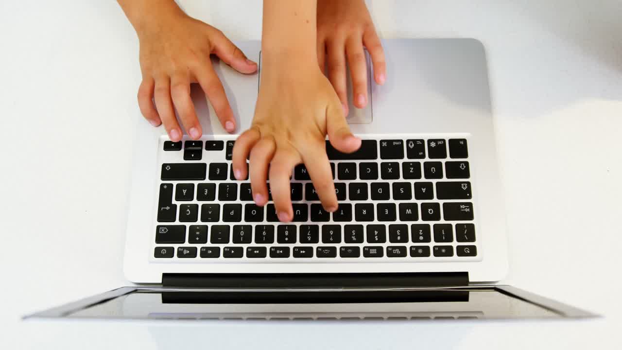 hermanos que usan portátiles en casa