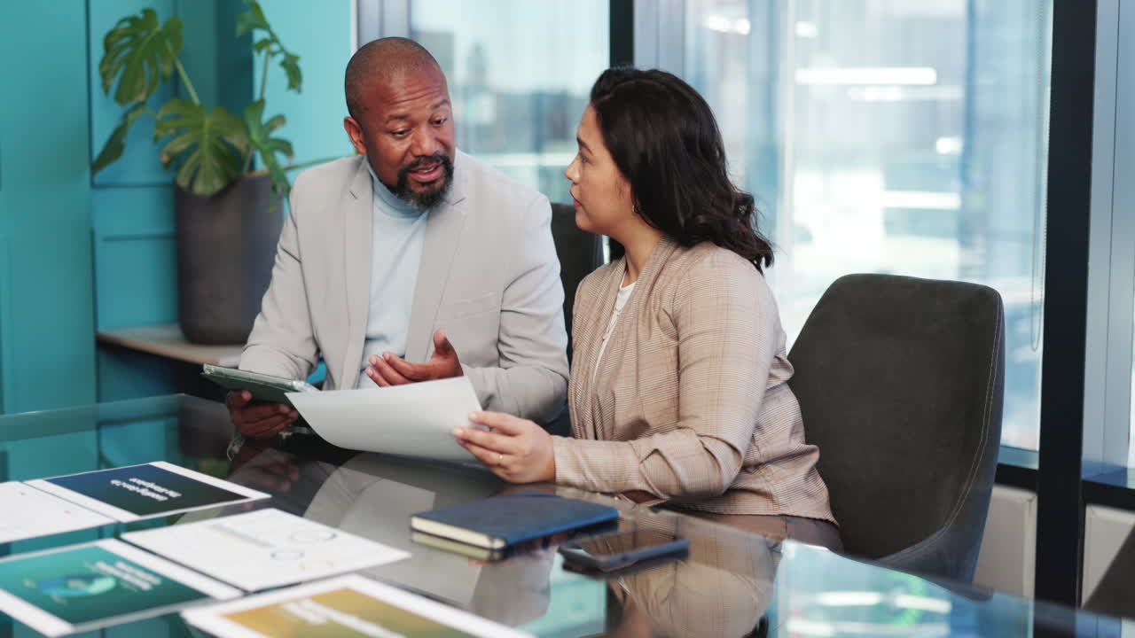 Two Diverse Business Colleagues Discussing Documents in a Modern Office Meeting