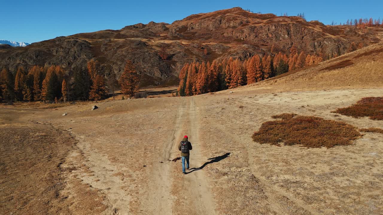 Hiker on a Mountain Trail in Autumn