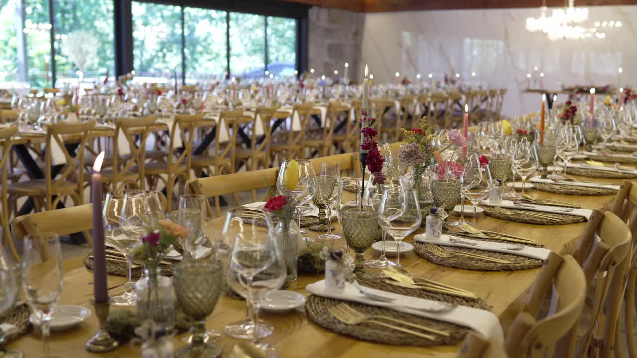 Elegant wedding banquet hall with floral centerpieces, candles, and fine glassware
