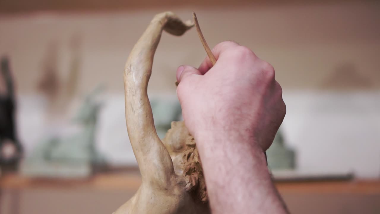 esculpiendo una figura de arcilla