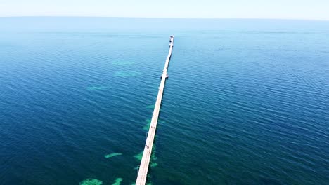aerial - drone shot of jetty stretching out to sea, western australia