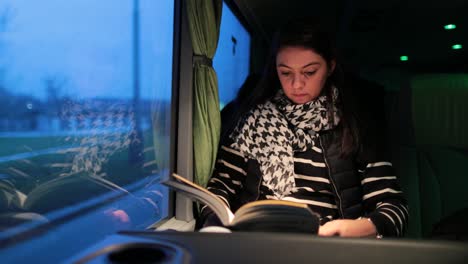 joven leyendo un libro mientras viaja en autobús por la carretera en 4k