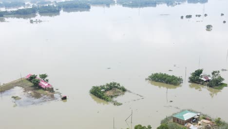 a school and rural village houses submerged in flood water. severe flooding aerial view