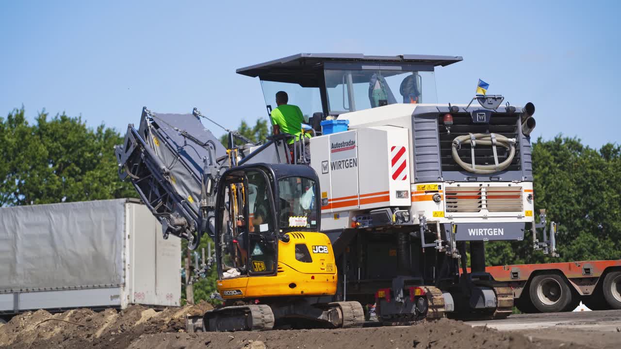 Special machinery during roadworks. Asphalt replacement on the highway on a summer day. Road rollers working on new road construction site.