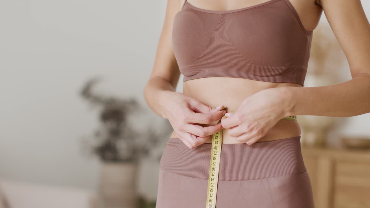 테이프 측정기로 허리를 측정하는 여자