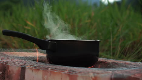 water boiling in a pot at campfire