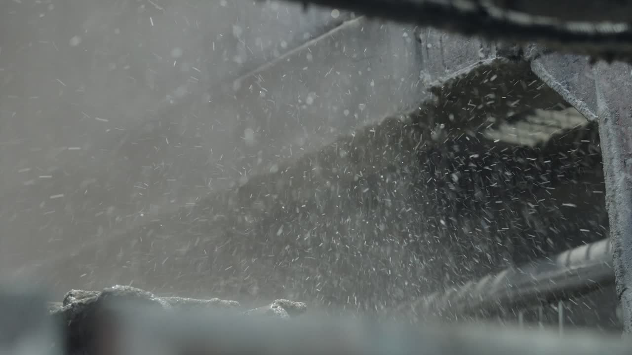 Ripresa al rallentatore di particelle di liquido che si disperdono nell'aria quando colpiscono una superficie meccanica, catturata in un'inquadratura fissa