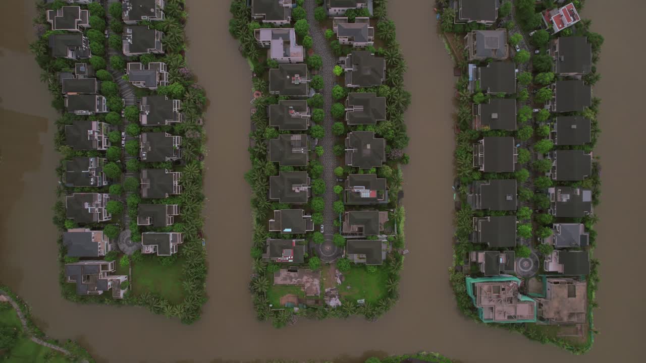 Top-down view of houses lined up on small water-bound islands in Hanoi, Vietnam, illustrating the concept of unique urban planning and harmonious coexistence with nature